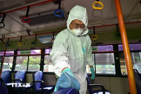 Nhân viên y tế Hàn Quốc khử trùng xe buýt tại thủ đô Seoul ngày 15/6 để ngăn chặn sự lây lan của MERS. (Ảnh: AFP/TTXVN) 