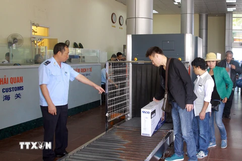 Nhân viên hải quan giám sát hành lý của khách nhập cảnh qua cửa khẩu Móng Cái. (Ảnh: Hoàng Hùng/TTXVN)