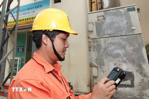 Công nhân Công ty Điện lực Hoàn Kiếm, Hà Nội áp dụng ghi chỉ số côngtơ bằng hệ thống đo xa. (Ảnh: Ngọc Hà/TTXVN)