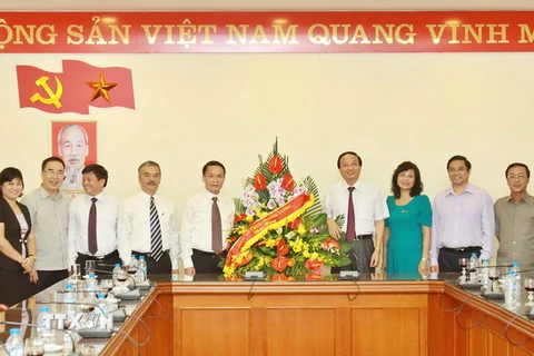 Trưởng Ban Tổ chức Trung ương Tô Huy Rứa tặng hoa chúc mừng Thông tấn xã Việt Nam nhân kỷ niệm 90 năm Ngày Báo chí Cách mạng Việt Nam. (Ảnh: Minh Quyết/TTXVN)