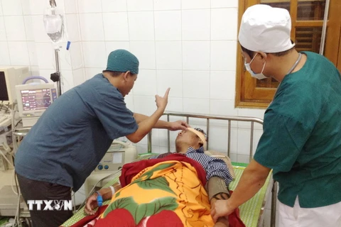 Các y bác sỹ Bệnh viện Đa khoa huyện đảo Bạch Long Vỹ điều trị cho ngư dân Nguyễn Văn Thịnh bị tai nạn do cơn bão số 1. (Ảnh: Nguyễn Đức Quân/TTXVN)