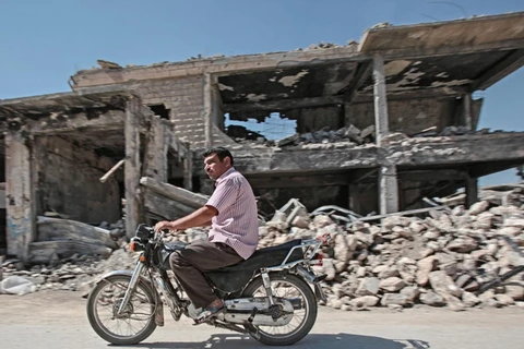 Một người dân đi qua những tòa nhà bị phá hủy trong các thị trấn Kobani của Syria vào tháng trước. (Nguồn: theguardian.com)