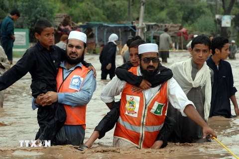 Nhân viên cứu hộ sơ tán người dân khỏi khu vực ngập lụt sau những trận mưa lớn tại Peshawar, Tây Bắc Pakistan ngày 26/7 vừa qua. (Ảnh: THX/TTXVN)
