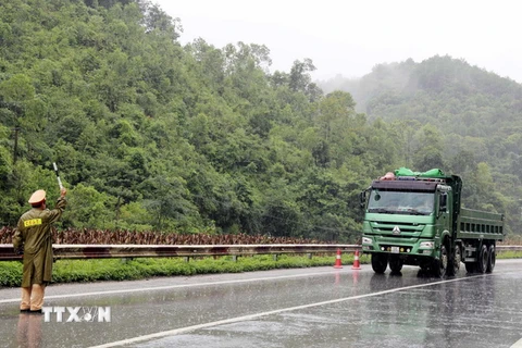 Cảnh sát Giao thông tỉnh Lạng Sơn phân luồng đảm bảo an toàn giao thông tại điểm sạt lở Km 25+200 trên Quốc lộ 1A. (Ảnh: Thái Thuần/TTXVN)