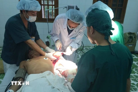 Các bác sỹ Bệnh viện Đa khoa Bạch Long Vỹ tiến hành phẫu thuật cho ngư dân Phạm Văn Thiết bị đứt rời cánh tay. (Ảnh: Nguyễn Văn Quân/TTXVN)