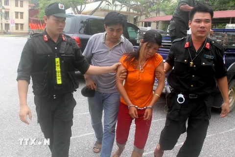Lực lượng công an áp giải nghi can Nguyễn Thị Hán ngày 15/8. (Ảnh: Thế Duyệt/TTXVN)