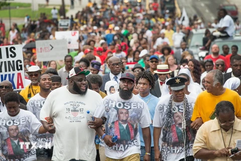 Người dân địa phương tuần hành tại lễ tưởng niệm một năm thanh niên da màu Michael Brown bị bắn chết tại Ferguson, Missouri ngày 9/8 vừa qua. (Ảnh: AFP/TTXVN)