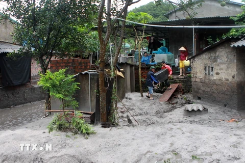 Người dân ở Cẩm Phả chuyển tài sản trước khi bùn thải tràn vào nhà trong đợt mưa lũ lịch sử. (Ảnh: Minh Quyết/TTXVN)