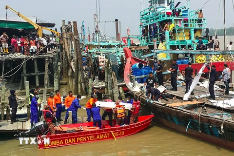 Nhóm cứu hộ Malaysia chuyển thi thể nạn nhân vụ chìm tàu ở Sabak Bernam ngày 3/9. (Ảnh: AFP/TTXVN)