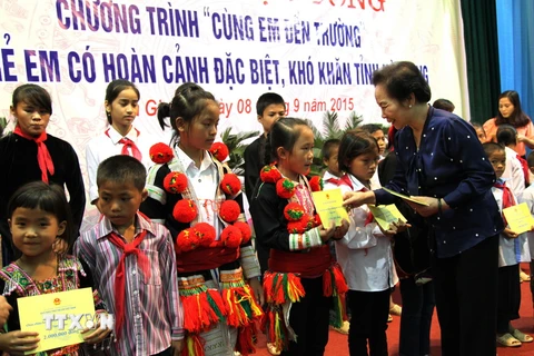 Phó Chủ tịch nước, kiêm Chủ tịch Hội đồng Bảo trợ Quỹ Bảo trợ trẻ em Việt Nam Nguyễn Thị Doan dự và trao học bổng cho các em. (Ảnh: Minh Tâm/TTXVN)