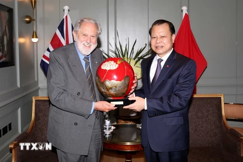 Phó Thủ tướng Vũ Văn Ninh trao tặng quà lưu niệm với Huân tước David Terence Puttnam. (Ảnh: Như Mai/TTXVN)