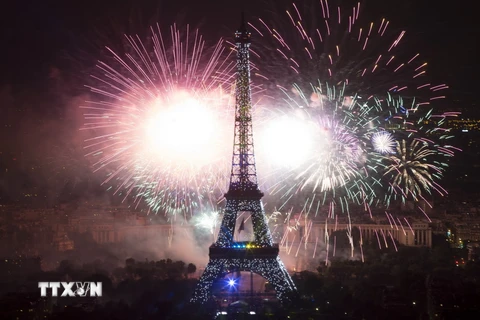 Pháo hoa được bắn lên bầu trời quanh tháp Eiffel ở thủ đô Paris, mừng ngày Quốc khánh Pháp 14/7 vừa qua. (Ảnh: AFP/TTXVN)