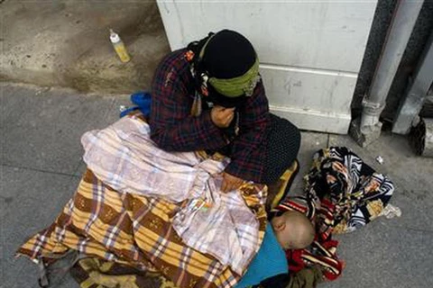 Một phụ nữ Italy vô gia cư cùng con trai. (Nguồn: Reuters)