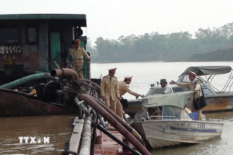 Lực lượng Cảnh sát giao thông đường thủy - Công an tỉnh Bắc Ninh bắt giữ tàu BKS HD0612 khai thác cát sỏi trái phép trên sông Đuống. (Ảnh: Thái Hùng/TTXVN)