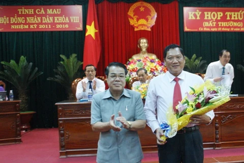 Bí thư Tỉnh ủy Cà Mau Dương Thanh Bình (bên trái) tặng hoa chúc mừng tân Phó Chủ tịch UBND tỉnh Cà Mau Lâm Văn Bi. (Nguồn: camau.gov.vn)