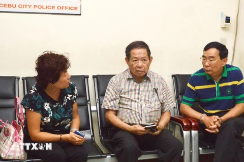 Hai người Trung Quốc gồm nhân viên lãnh sự quán (trái) và nghi phạm vụ tấn công (phải, bị còng tay) tại sở cảnh sát ở thành phố Cebu, Philippines ngày 21/10 vừa qua. (Ảnh: AFP/TTXVN)