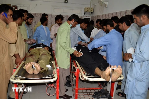 Bác sỹ khám nghiệm tử thi hai cảnh sát thiệt mạng trong đọ súng gữa cảnh sát và các tay súng tại Quetta, tây nam Pakistan ngày 27/7 vừa qua. (Ảnh: THX/TTXVN)