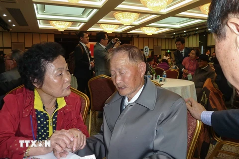 Bà Sun Kum-Soon (trái), 75 tuổi, người Hàn Quốc đoàn tụ với anh họ là Sun Yong-Ju (giữa), 82 tuổi, trong cuộc đoàn tụ ở Kumgang ngày 22/10 vừa qua. (Ảnh: AFP/TTXVN)