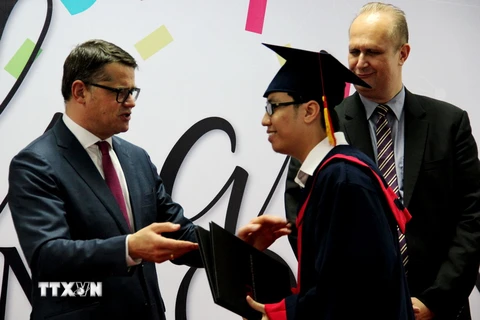 Bộ trưởng Bộ Khoa học và Nghệ thuật Cộng hòa liêng bang Đức Boris Rhein (trái) trao bằng tốt nghiệp cho sinh viên. (Ảnh: Dương Chí Tưởng/TTXVN)