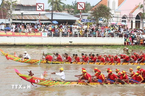 Hai đội ghe Ngo nam đang nước rút về đích tại giải đua ghe Ngo trong Ngày hội Văn hóa, Thể thao và Du lịch đồng bào Khmer Nam bộ lần thứ 6, năm 2014. (Ảnh: Xuân Dự/TTXVN)