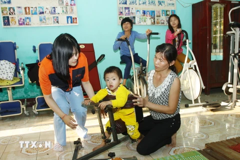Các tình nguyện viên người Hàn Quốc phục hồi chức năng cho trẻ em khuyết tật. (Ảnh: Hồ Cầu/TTXVN)