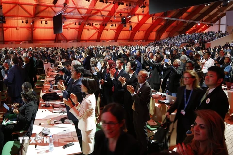 Các đại biểu hoan nghênh quyết định thông qua Thỏa thuận Paris 2015 về chống biến đổi khí hậu tại Le Bourget ngày 12/12. (Ảnh: AFP/TTXVN)