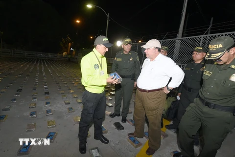 Bộ trưởng Quốc phòng Colombia Luis Carlos Villegas (giữa) và Giám đốc cơ quan cảnh sát quốc gia Rodolfo Palomino (phải) thị sát việc kiểm tra số ma túy vừa thu giữ tại Cartagena ngày 13/1 vừa qua. (Ảnh: THX/TTXVN)
