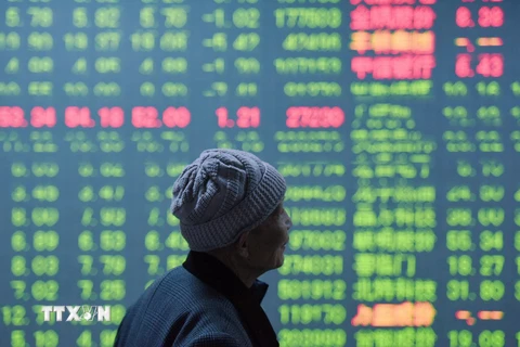 Nhà đầu tư theo dõi tỷ giá chứng khoán tại Hàng Châu, tỉnh Chiết Giang, miền đông Trung Quốc ngày 11/1 vừa qua. (Ảnh: AFP/TTXVN)