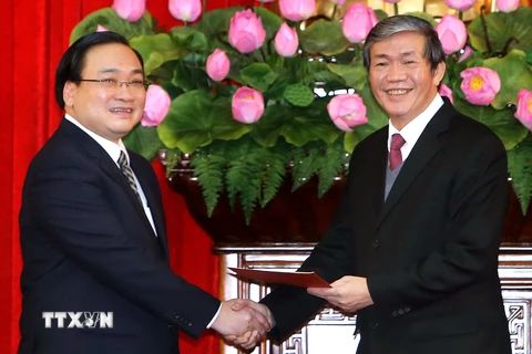 Thường trực Ban Bí thư Đinh Thế Huynh (phải) trao quyết định phân công Ủy viên Bộ Chính trị, Phó Thủ tướng Hoàng Trung Hải giữ chức Bí thư Thành ủy Hà Nội. (Ảnh: An Đăng/TTXVN).