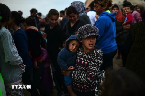 Người tị nạn và di cư xếp hàng đợi nhận khẩu phần ăn tại trại tị nạn ở Idomeni, biên giới Hy Lạp và Macedonia ngày 5/4. (Ảnh: AFP/TTXVN)