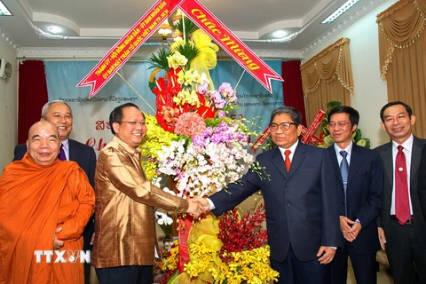 Ông Tất Thành Cang chúc mừng Tổng lãnh sự Lào Somxay Sanam-oune. (Ảnh: Phương Vy/TTXVN)