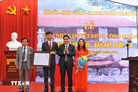 Cục phó cục Di sản trao quyết định công nhận pho tượng Trấn Vũ - Bảo vật quốc gia cho lãnh đạo phường Thạch Bàn - quận Long Biên. (Ảnh: Minh Đức/TTXVN)