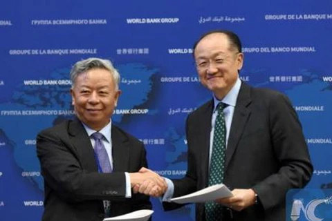 Chủ tịch WB Jim Yong Kim (phải) và Chủ tịch AIIB Kim Lập Quần ký thỏa thuận về chương trình cho vay vốn chung đầu tiên. (Nguồn: THX)