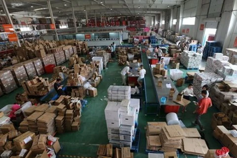 Công nhân đóng gói hàng hoá nhập khẩu tại Trung tâm Thương mại điện tử Trịnh Châu qua biên giới, trung tâm tỉnh Hà Nam của Trung Quốc. (Nguồn: Xinhua)