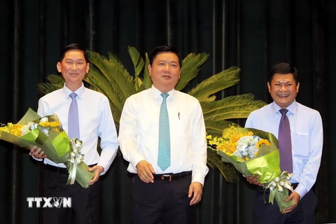 Bí thư Thành ủy Thành phố Hồ Chí Minh Đinh La Thăng chúc mừng 2 tân Phó Chủ tịch UBND Trần Vĩnh Tuyến và Huỳnh Cách Mạng. (Ảnh: Thanh Vũ/TTXVN)