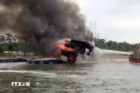 Lực lượng Cảnh sát Phòng cháy chưa cháy Quảng Ninh khẩn trương phun nước dập đám cháy lớn đang bùng phát dữ dội trên tàu du lịch QN 6299. (Ảnh: TTXVN)