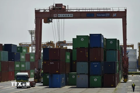 Bốc dỡ hàng hóa tại cảng Aomi ở Tokyo ngày 18/5 vừa qua. (Ảnh: EPA/TTXVN)