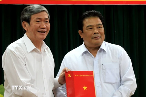 Thường trực Ban Bí thư Đinh Thế Huynh (trái) trao quyết định của Bộ Chính trị cho ông Sơn Minh Thắng. (Ảnh: Ngọc Thiện/TTXVN)