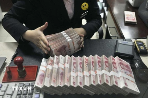 Kiểm đồng nhân dân tệ tại một ngân hàng ở Trung Quốc. (Ảnh: Reuter/TTXVN)