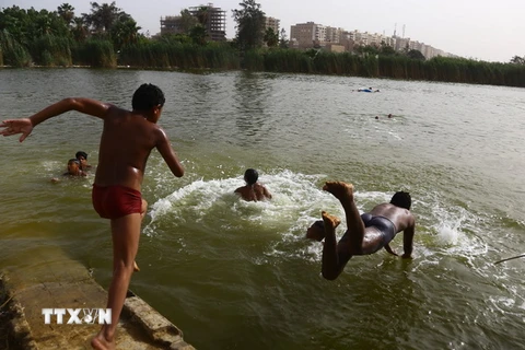 Trẻ em tắm mát trên sông Nile ở thủ đô Cairo, Ai Cập để tránh nắng nóng ngày 15/5 vừa qua. (Ảnh: THX/TTXVN)