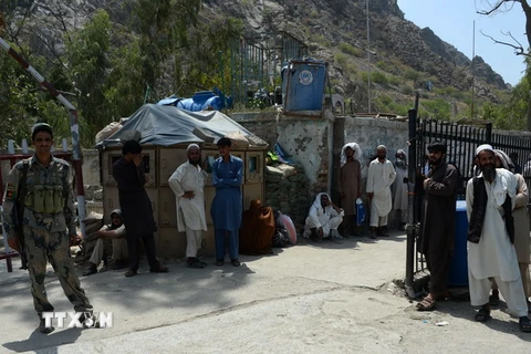 Người dân Afghanistan đợi qua cửa khẩu Torkham ngày 18/6. (Ảnh: AFP/TTXVN)