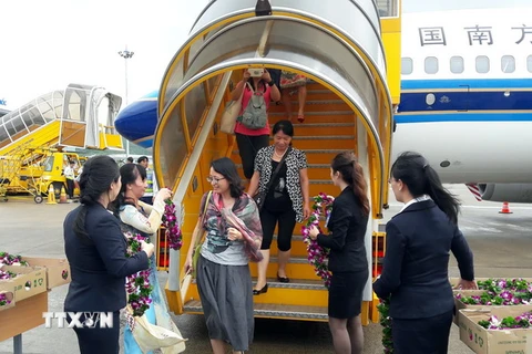 Những khách du lịch đầu tiên trên chuyến bay của CZ đến Phú Quốc. (Ảnh: Lê Huy Hải/TTXVN)