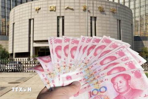 Đồng tiền giấy mệnh giá 100 nhân dân tệ được giới thiệu bên ngoài Ngân hàng PBOC tại Bắc Kinh. (Ảnh: Kyodo/TTXVN)