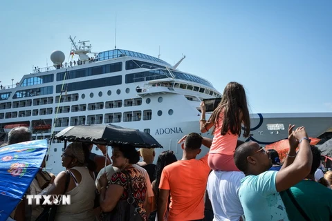 Người dân Cuba chào đón các hành khách trên du thuyền "The Adonia" tại cảng La Habana. (Ảnh: AFP/TTXVN)