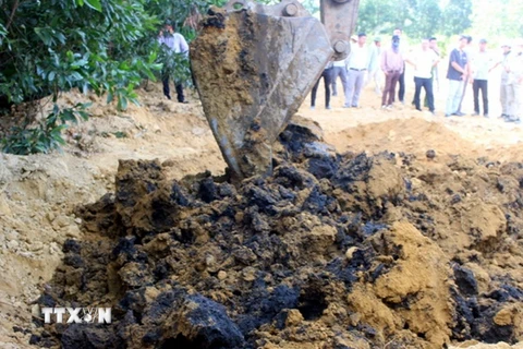Lực lượng chức năng dùng máy xúc để đào chất thải của Công ty Formosa Hà Tĩnh chôn lấp tại trang trại ông Lê Quang Hòa, tại phường Kỳ Trinh, thị xã Kỳ Anh. (Ảnh Phan Quân/TTXVN)