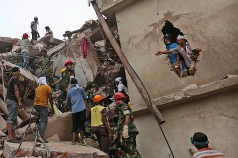 Nhân viên cứu hộ tìm kiếm người sống sót sau sự sụp đổ của khu tổ hợp may Rana Plaza ở Savar, hồi tháng 4/2013. (Nguồn: AP)