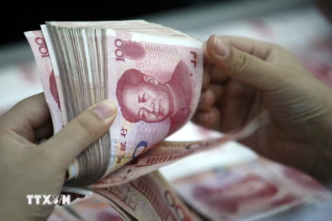 Kiểm tiền mệnh giá 100 nhân dân tệ tại chi nhánh ngân hàng ở Hoài Bắc, tỉnh An Huy, Trung Quốc. (Ảnh: EPA/TTXVN)