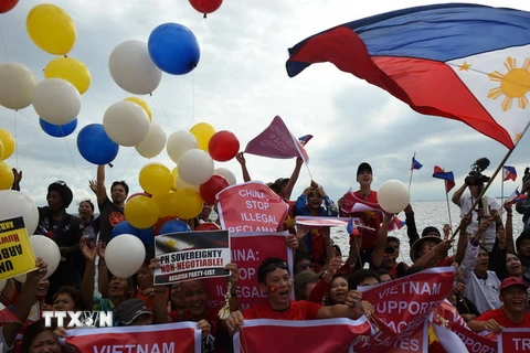 Các nhà hoạt động Philippines vui mừng sau phán quyết của Tòa Trọng tài ở Lahay trong cuộc tuần hành tại Manila ngày 12/7 vừa qua. (Ảnh: AFP/TTXVN)