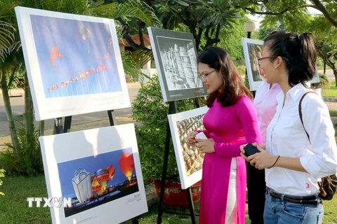 Các đại biểu và khách tham quan xem Triển lãm ảnh Di sản Việt Nam 2015. (Ảnh: Nguyễn Thanh/TTXVN)