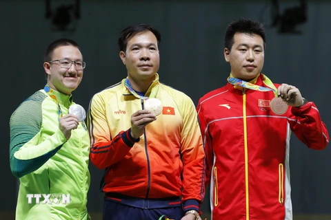 Xạ thủ Hoàng Xuân Vinh (giữa) ngày 6/8 nhận giành huy chương vàng nội dung 10m súng ngắn hơi nam tại Đại hội thể thao thế giới (Olympic) 2016. (Ảnh: EPA/TTXVN)